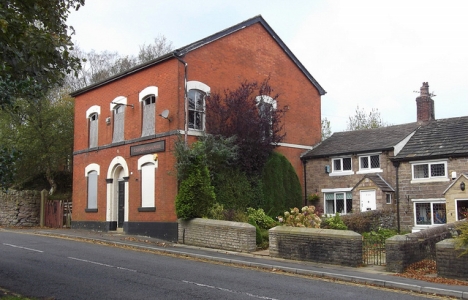 A brick building that housed the Corporation Park Pub in Blackburn, and neighboring houses.