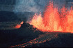 A volcanic fissure erupting in a curtain of lava and smoke.